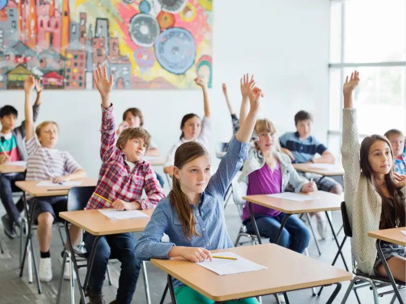 students-with-arms-raised-in-classroom