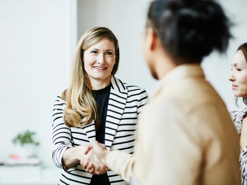 smiling-businesswoman-shaking-hands-with-client