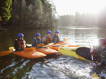 Teacher capsizing kayak in still lake