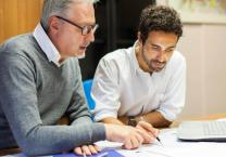 Older man teaching a younger man