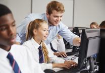 Image of a young person and teacher using a computer