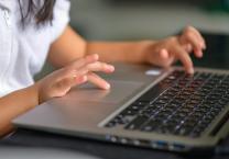 Child typing on a computer